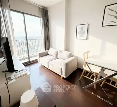 Bright living room with cozy sofa and balcony view, perfect for relaxation.