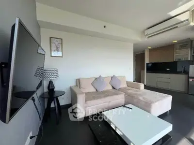 Modern living room with sleek furniture and open kitchen layout in a stylish apartment.