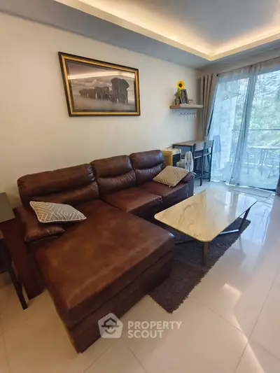 Cozy living room with leather sofa and marble coffee table, featuring a large window with balcony view.