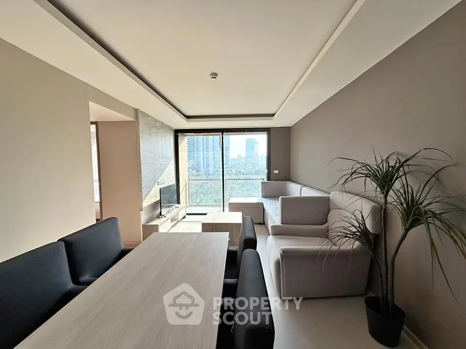 Modern living room with city view, sleek furniture, and natural light