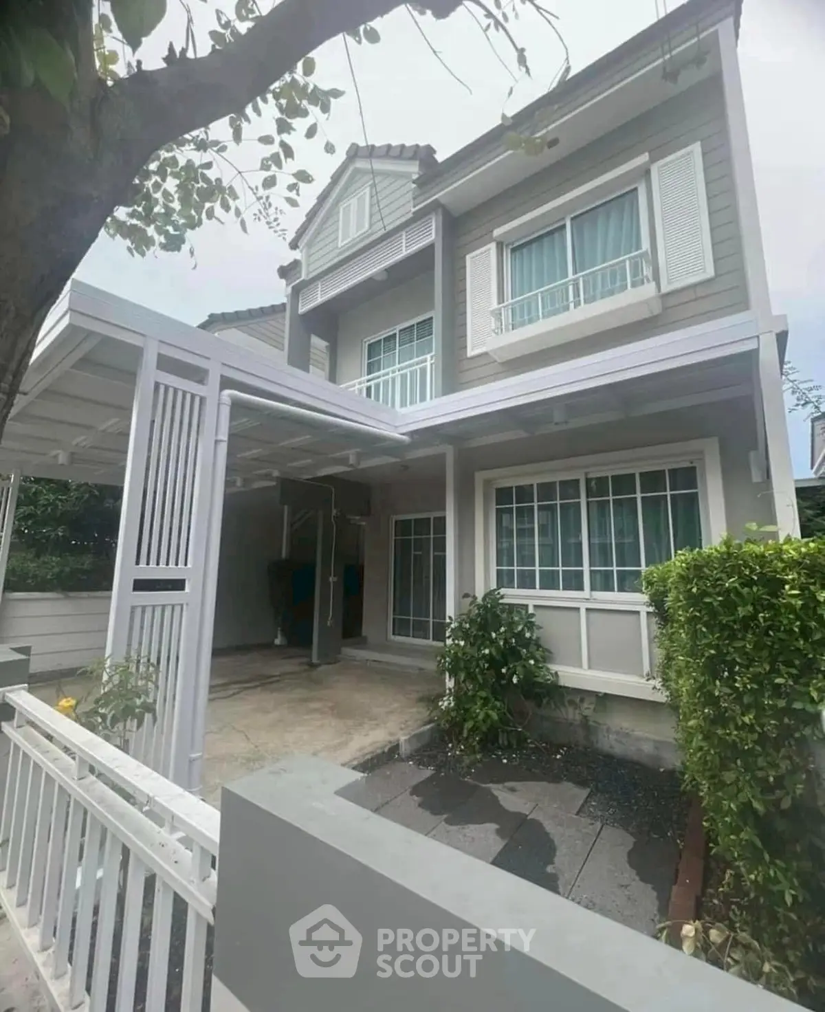 Charming two-story house with modern facade and lush greenery in front yard.