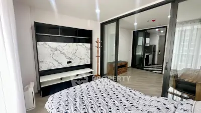 Modern bedroom with sliding glass doors and stylish decor in a contemporary apartment.