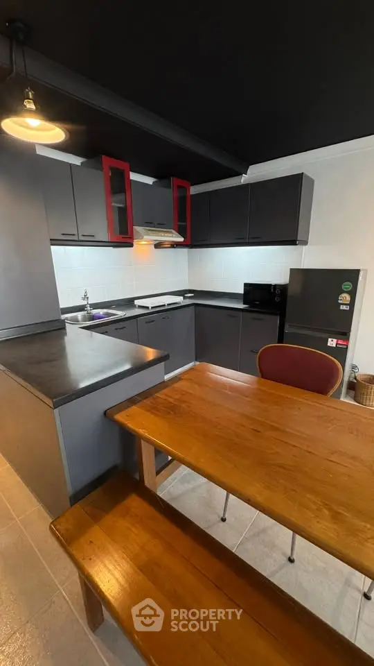 Modern kitchen with sleek cabinets and wooden dining table