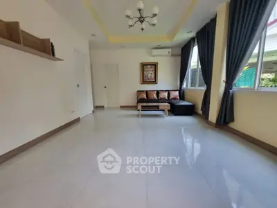 Spacious living room with modern decor and large windows for natural light