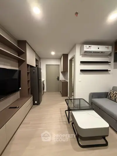 Modern living room with sleek furniture and built-in shelves, featuring a stylish air conditioning unit.