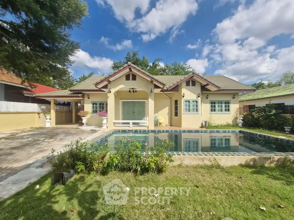 Charming single-story home with pool and lush garden under blue skies.