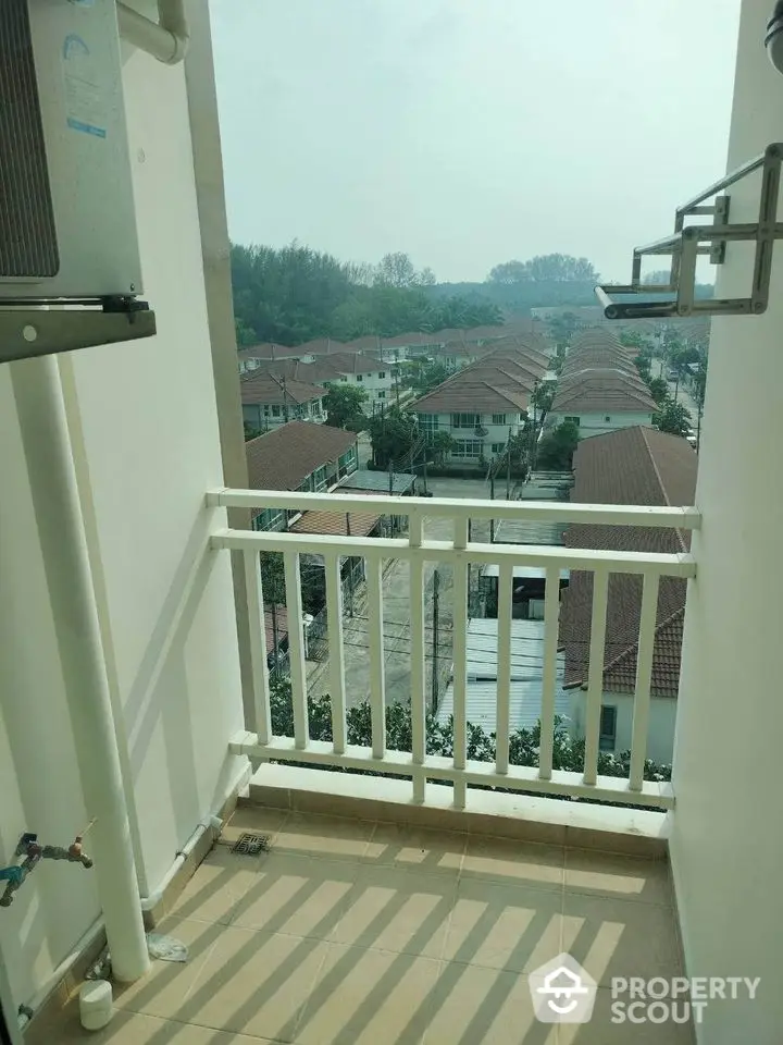 Charming balcony with scenic view of suburban houses and lush greenery.