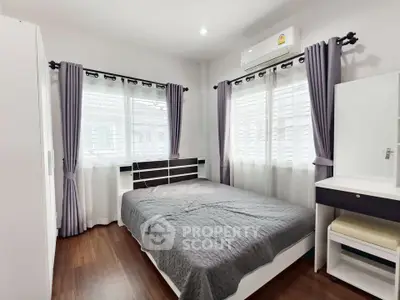 Bright and cozy bedroom with modern furnishings and ample natural light.