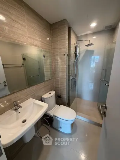 Modern bathroom with glass shower and sleek fixtures in a contemporary apartment.