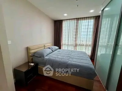Cozy bedroom with large window and modern furnishings in a stylish apartment.