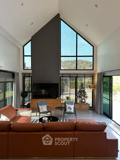 Spacious modern living room with high ceilings and large windows offering scenic views.