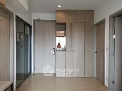 Modern apartment entrance with sleek wooden cabinetry and minimalist design.