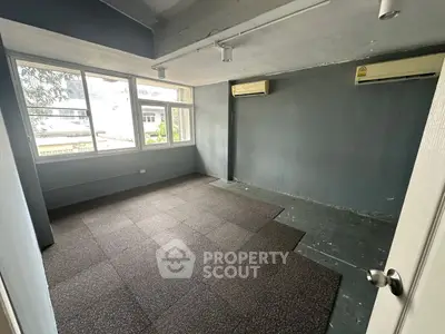 Spacious empty room with large windows and air conditioning, ideal for customization.