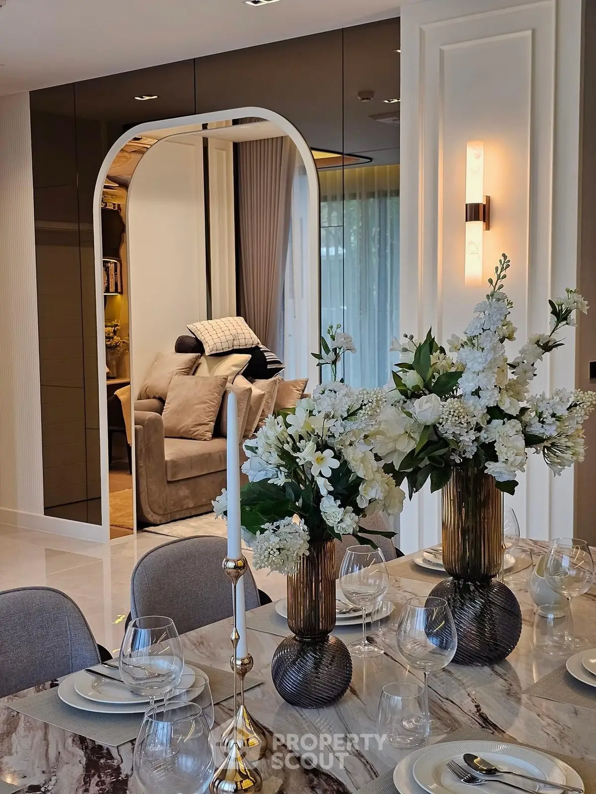 Luxurious dining area with elegant table setting and view into cozy living room