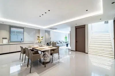 Luxurious open-plan living and dining area with modern furnishings and elegant lighting.