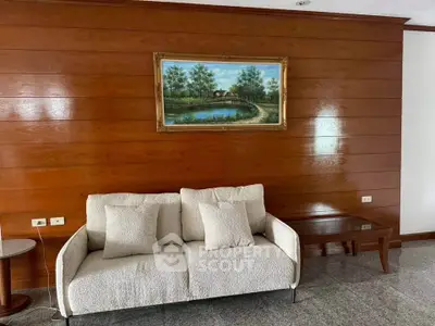 Cozy living room with elegant wooden paneling and plush sofa, perfect for relaxation.