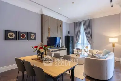 Elegant living room with modern decor and dining area, featuring stylish furniture and soft lighting.