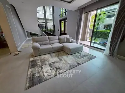 Spacious modern living room with large windows and stylish sofa, perfect for family gatherings.