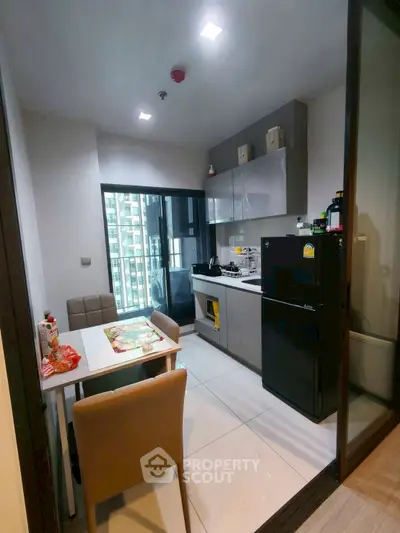 Modern kitchen with sleek appliances and dining area in a high-rise apartment.