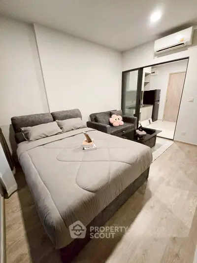 Cozy modern bedroom with stylish decor and plush bedding in a contemporary apartment.