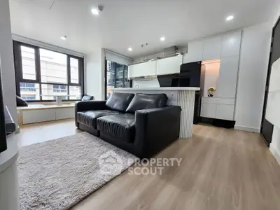 Modern living room with sleek black sofa and open kitchen layout