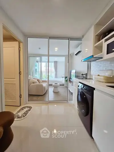 Modern open-layout kitchen with sleek appliances and view into cozy living room