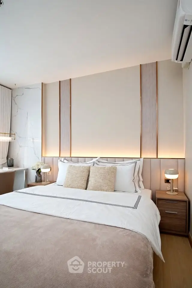 Luxurious bedroom with elegant lighting and modern decor, featuring a comfortable bed and stylish side tables.