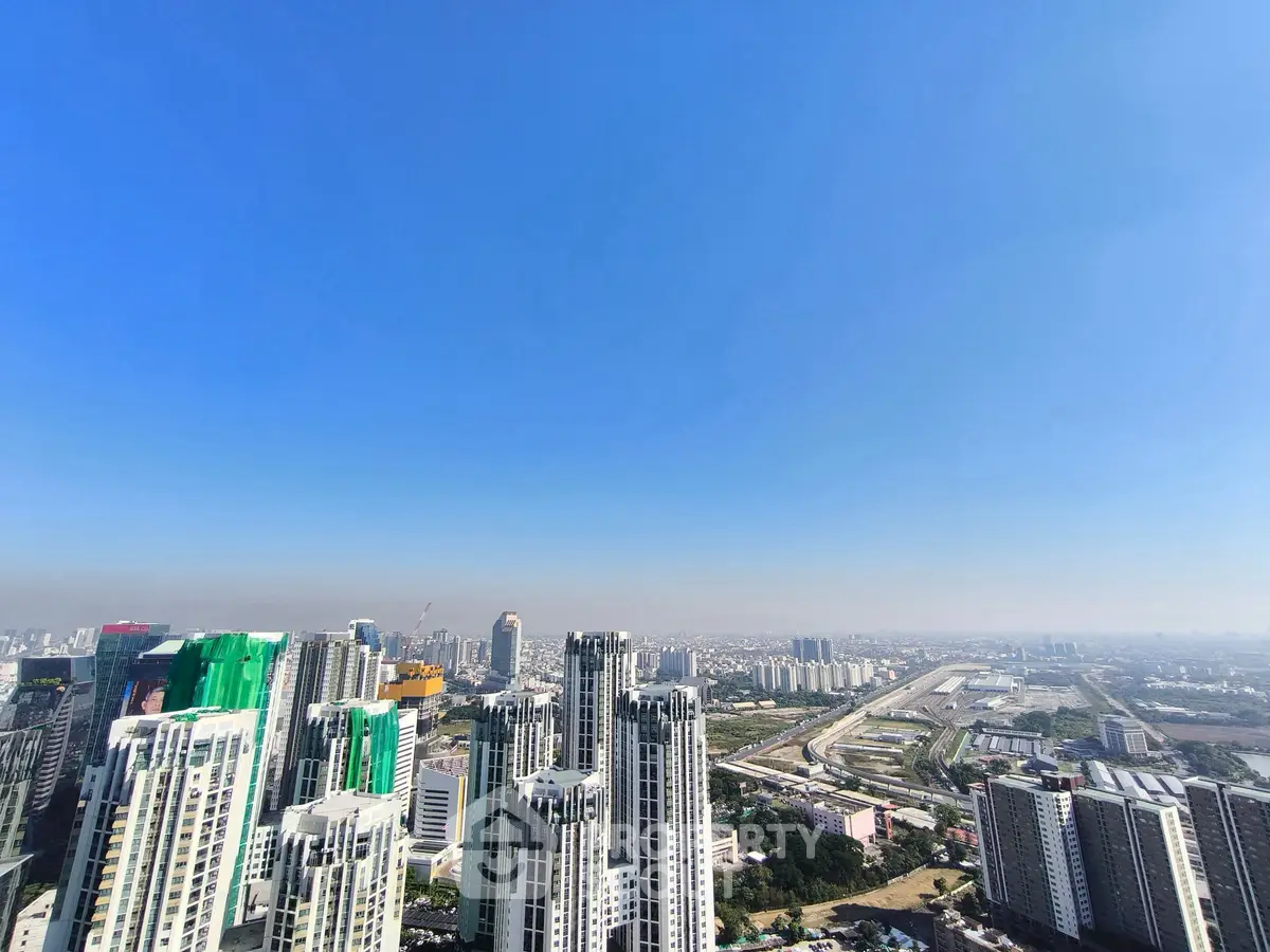 Stunning cityscape view from high-rise building showcasing urban skyline and clear blue sky.