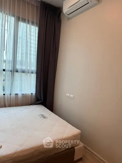 Cozy bedroom with natural light and modern air conditioning unit.