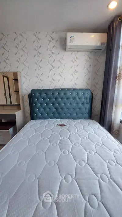 Cozy bedroom with elegant headboard and air conditioning, perfect for restful nights.