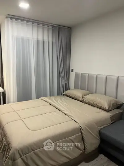 Modern bedroom with elegant curtains and cozy bedding in a stylish apartment.