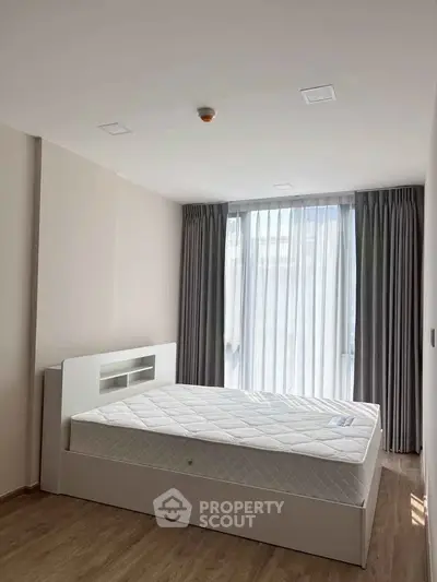 Spacious bedroom with large window and modern decor