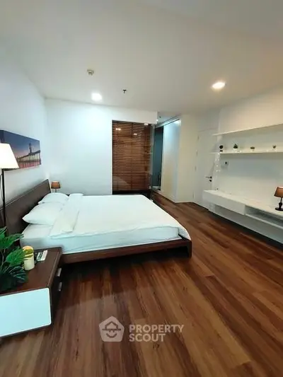 Spacious modern bedroom with wooden flooring and stylish decor