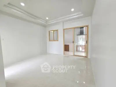 Spacious modern living room with sleek tile flooring and sliding glass doors
