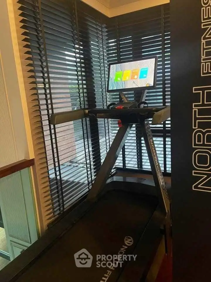 Modern gym with treadmill and large windows, perfect for fitness enthusiasts.