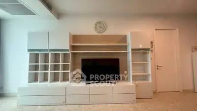 Modern living room with sleek entertainment unit and wall clock, perfect for stylish urban living.