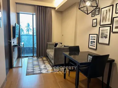 Modern living room with stylish decor, cozy seating, and a view of the balcony.
