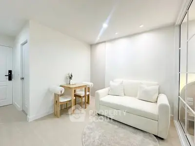 Bright and cozy living room with modern white sofa and dining area, perfect for relaxation and entertaining.