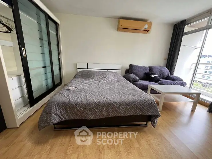 Modern bedroom with sleek furniture and large window offering natural light.