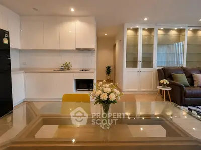 Modern open-plan kitchen and living area with elegant dining table and cozy seating.