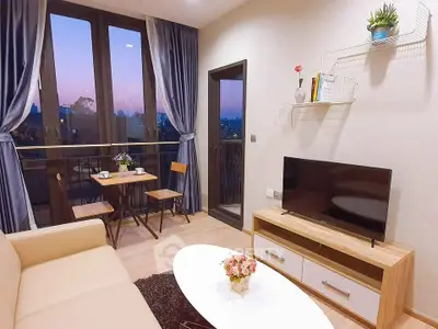 Charming living room with balcony view, cozy seating, and modern decor.
