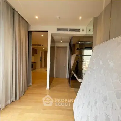 Spacious modern apartment interior with wooden flooring and large windows.