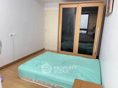 Cozy bedroom with wooden wardrobe and minimalist decor, perfect for a serene living experience.