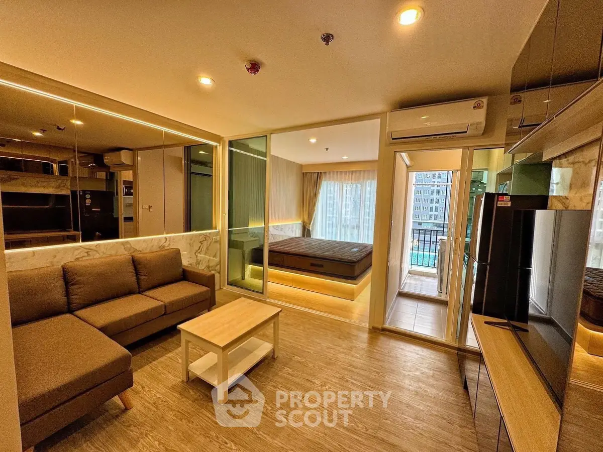Modern studio apartment with open layout, featuring a cozy living area and a spacious bedroom with balcony access.