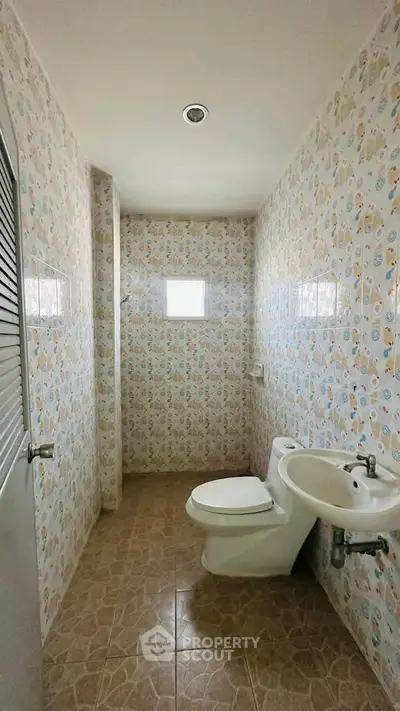 Cozy bathroom with patterned tiles and compact layout, perfect for small spaces.