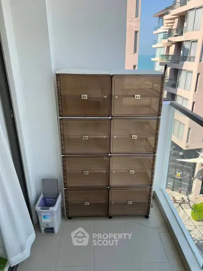 Modern balcony with storage unit and ocean view in high-rise apartment