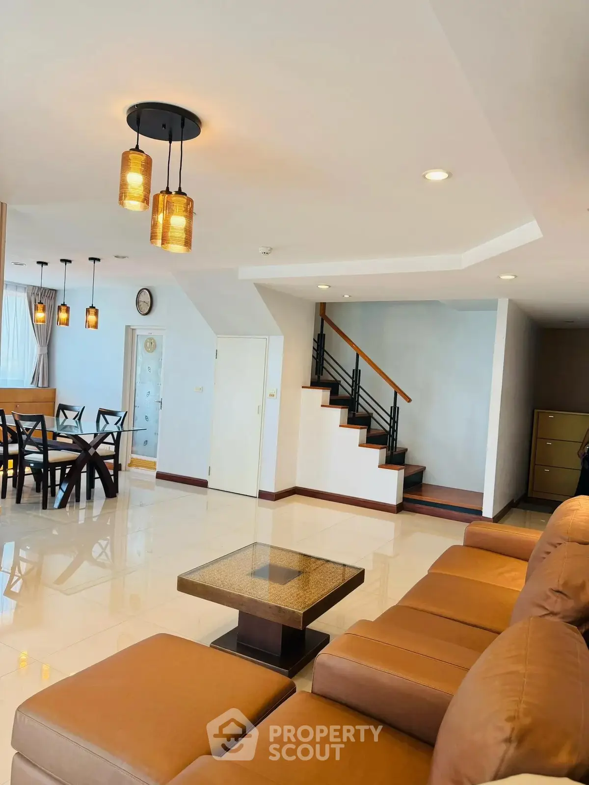 Spacious living room with modern decor and elegant staircase in a luxurious home.