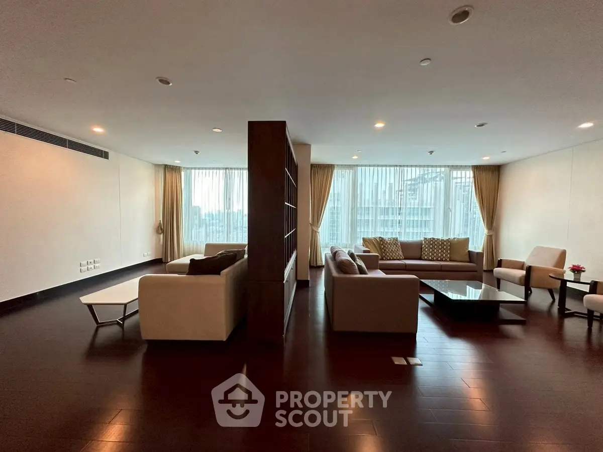 Spacious modern living room with elegant furniture and large windows offering natural light.