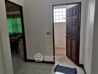 Cozy interior hallway leading to a tiled bathroom with natural light.