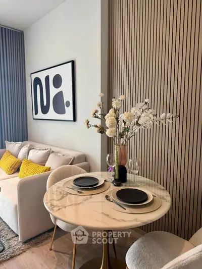 Stylish modern living room with elegant dining setup and cozy sofa.